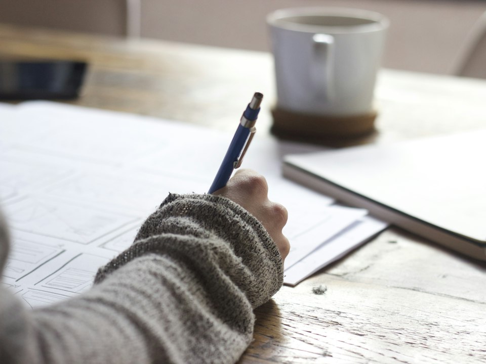 Student writing notes while studying