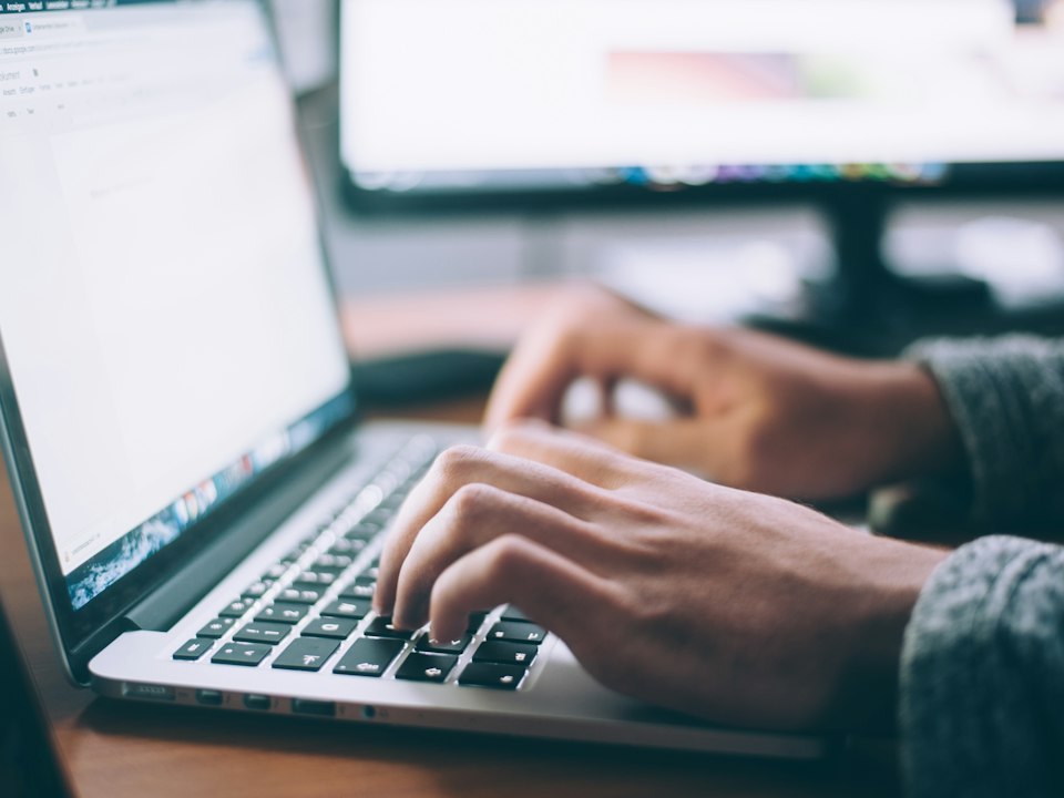 Person working on a laptop at a desk